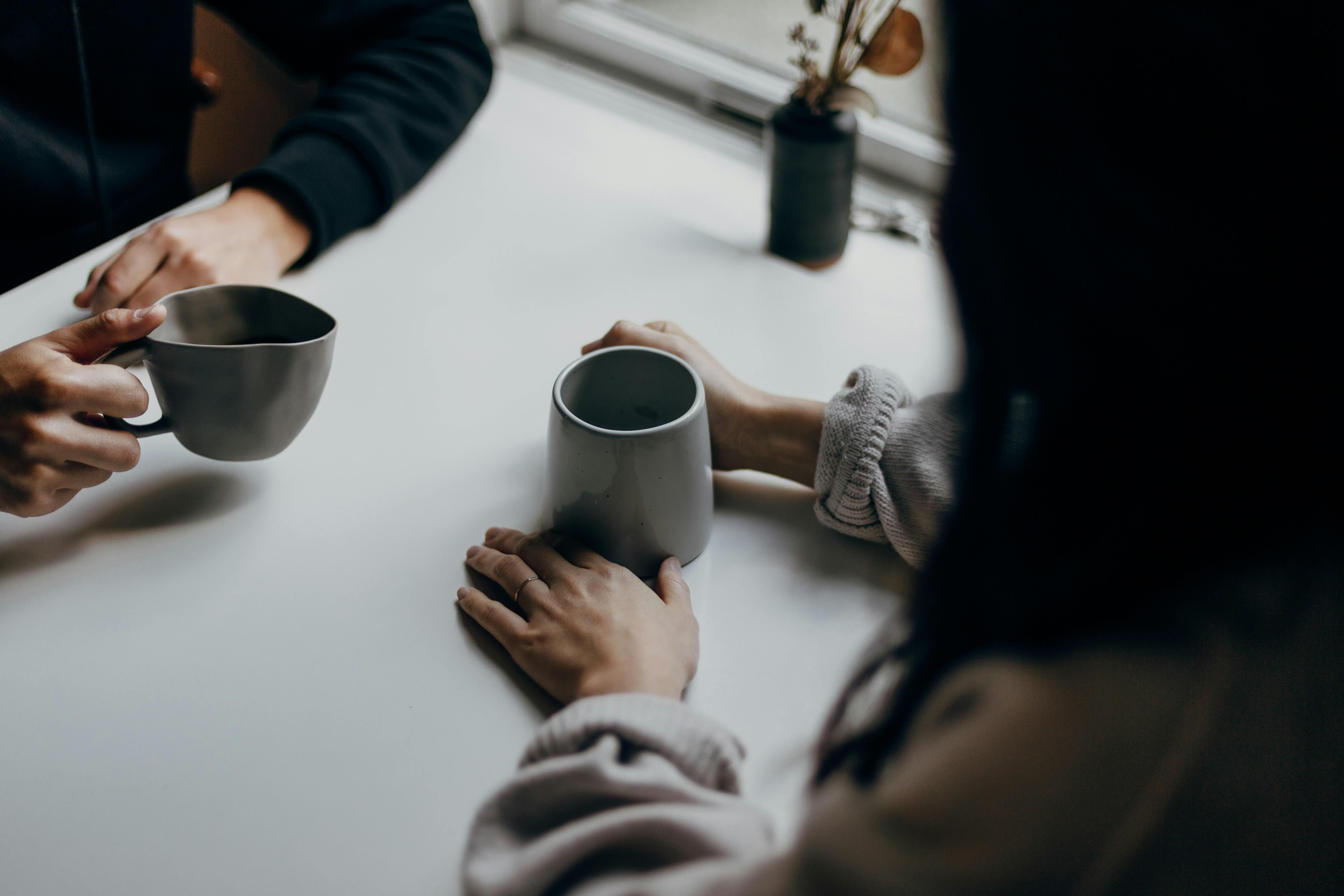 People having a conversation over coffee, representing a calm and welcoming therapy space